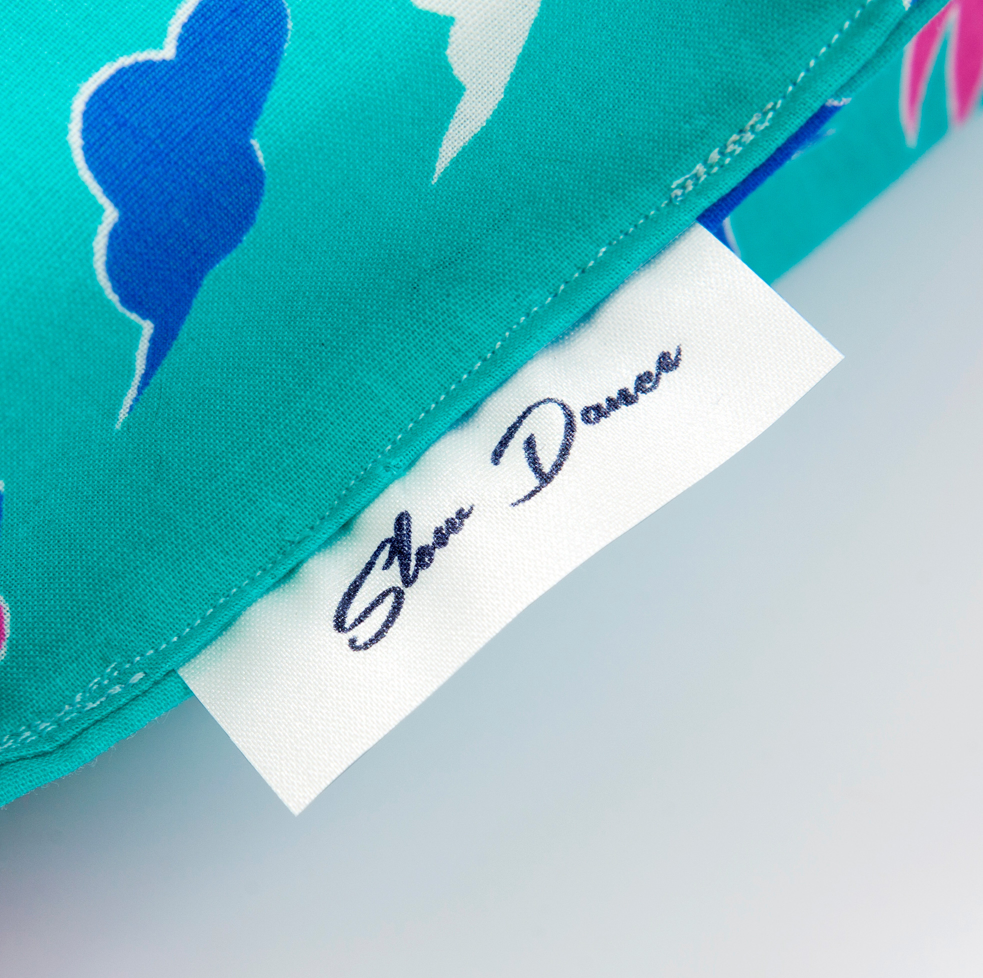 A close up image of a tag sewn into a teal life jacket